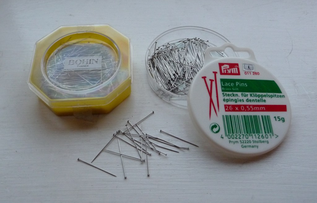 Two pots of silver coloured pins