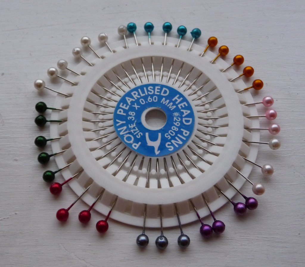 A pin wheel with coloured bead heads at the end of each pin