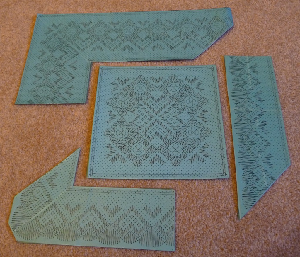 A lace pattern pricking covered in blue plastic with each hole pricked through