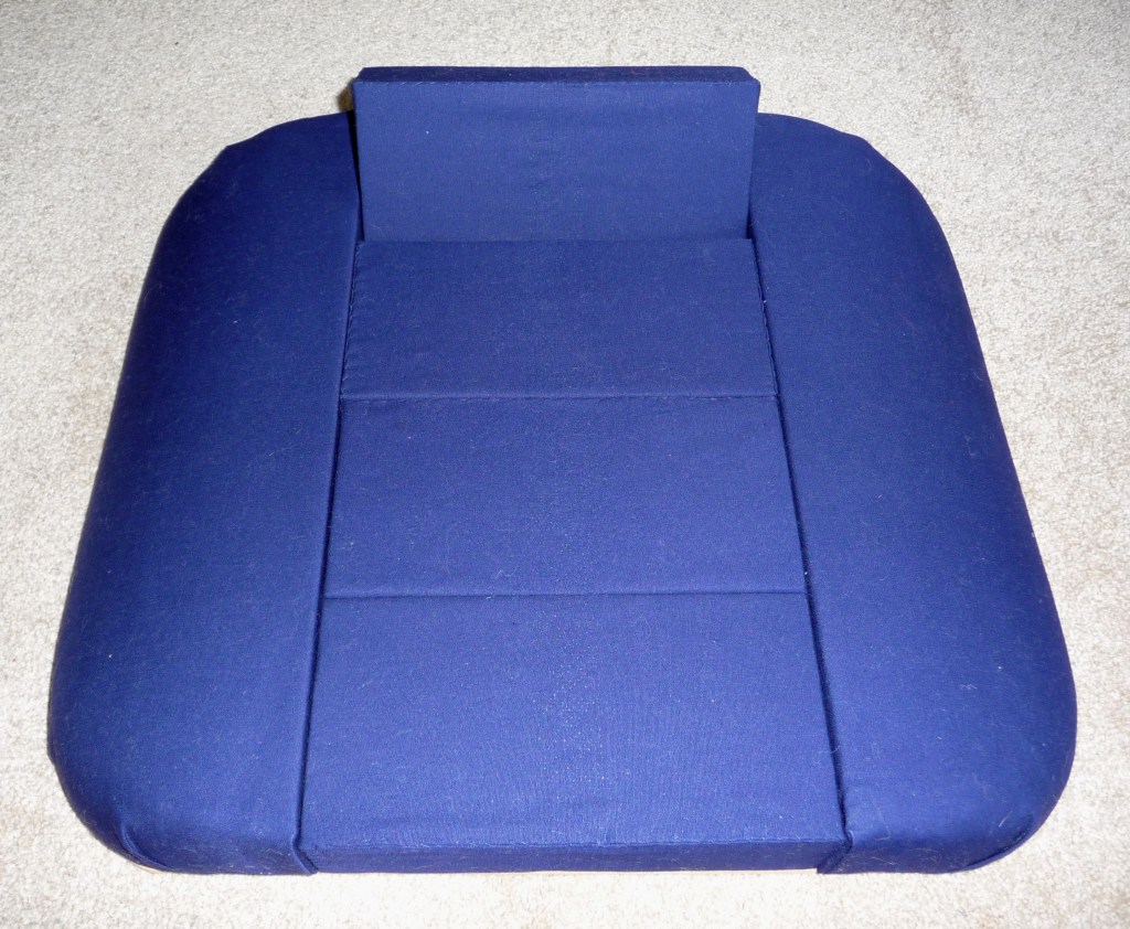 A square blocked lace cushion covered in blue fabric