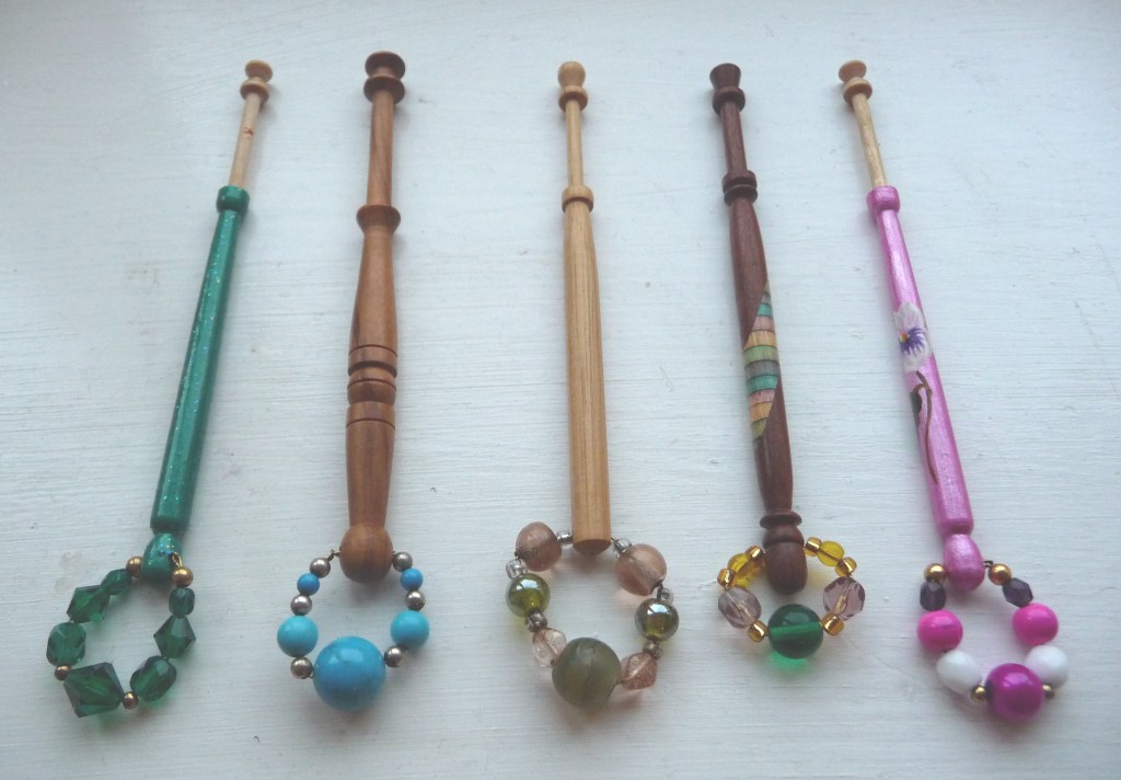 A selection of five painted East Midlands style lace bobbins, with beaded spangles at the end